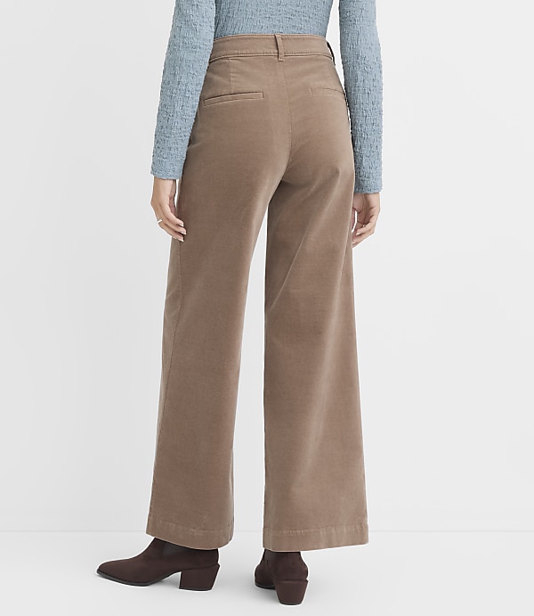 A person wearing wide-leg corduroy pants and brown boots stands against a plain white background.