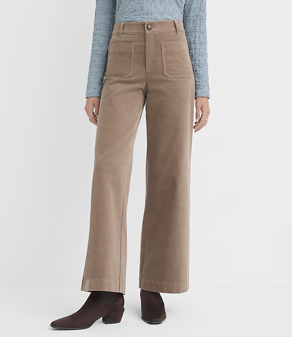 A person wearing tan corduroy wide-leg pants and brown boots stands against a plain white background.