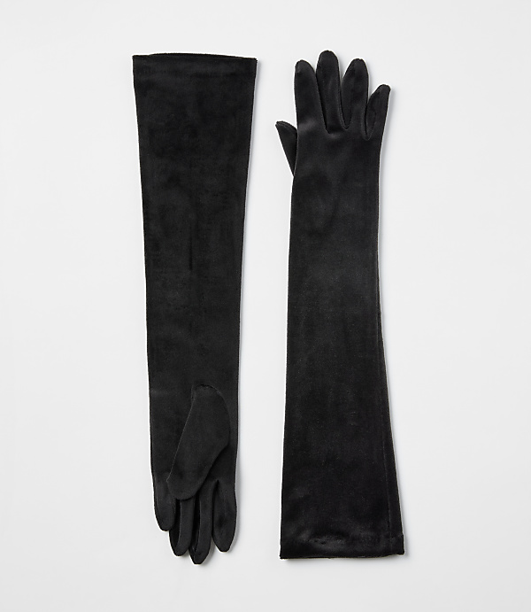A pair of long black velvet gloves lies flat against a plain white background.