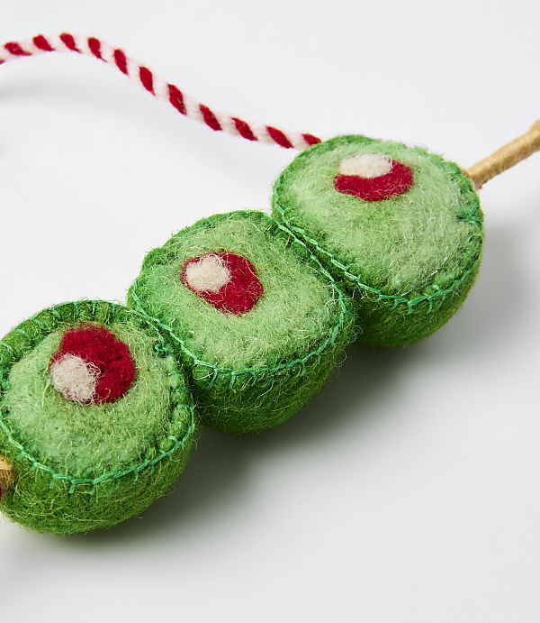 Three green felt sushi rolls with red centers are strung on a red and white twisted cord against a plain white background.