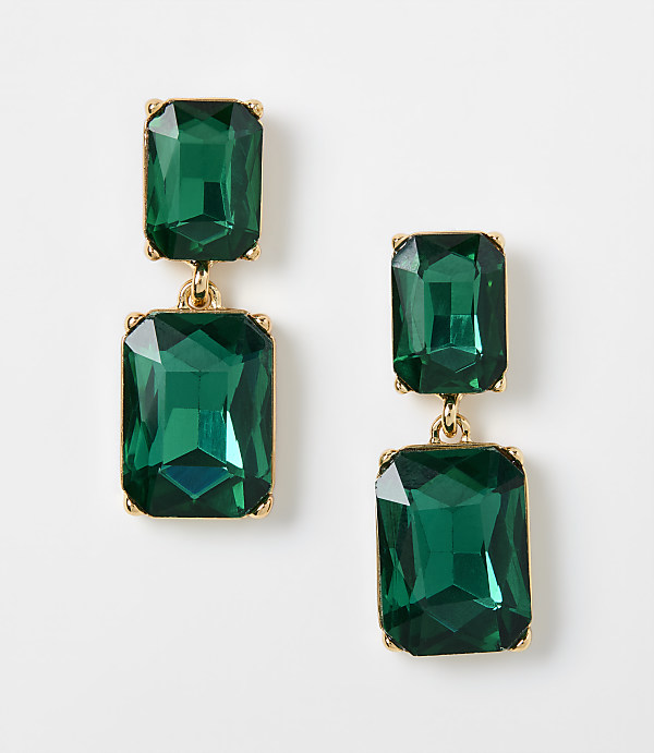 Two pairs of emerald green rectangular drop earrings with gold settings rest on a plain white background.