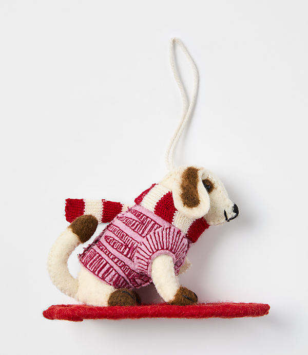 A small felt dog wearing a pink and white striped sweater stands on a red base against a plain white background.