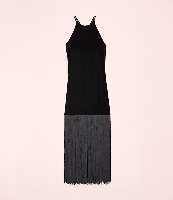 A black sleeveless dress with a fringed hem is centered against a solid light pink background.