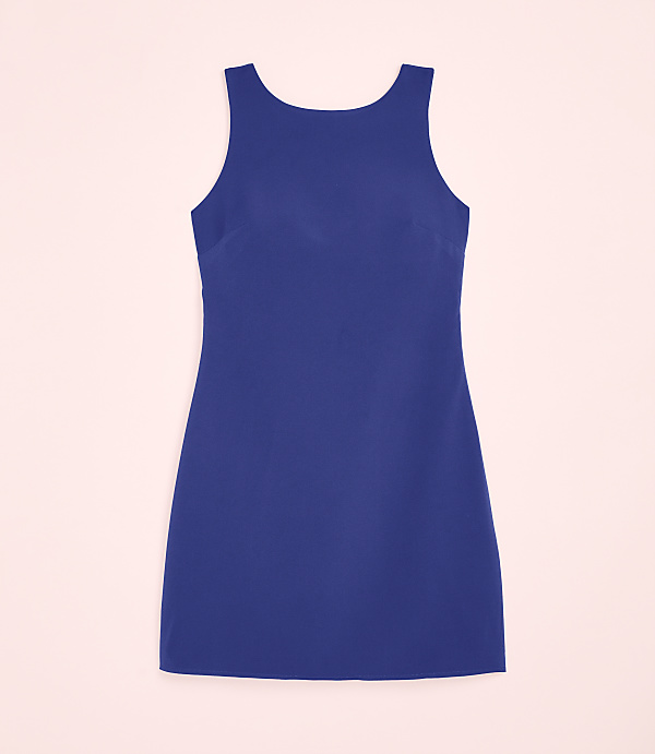 A sleeveless royal blue dress is centered against a pale pink background.