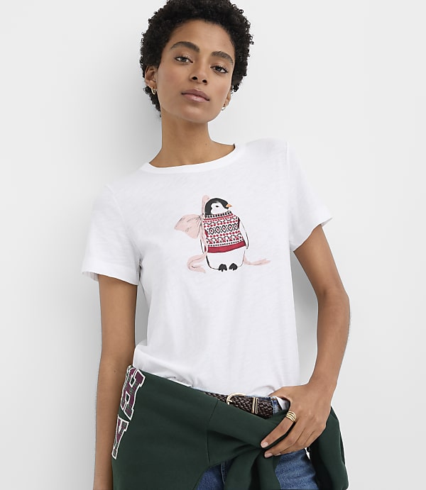 A woman wearing a white t-shirt with a penguin graphic stands against a plain white background.