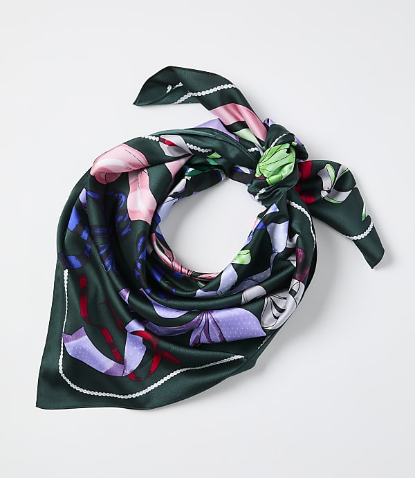 A green floral silk scarf is tied in a knot against a plain white background.