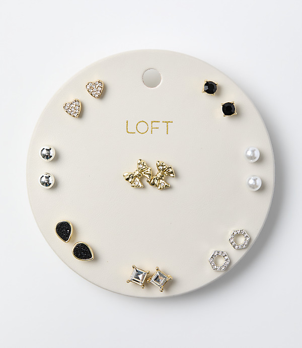 Various pairs of stud earrings are arranged on a circular white LOFT display card against a plain white background.