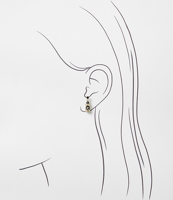 A small, ornate earring hangs from the ear of a minimalist line drawing of a woman's profile against a plain white background.