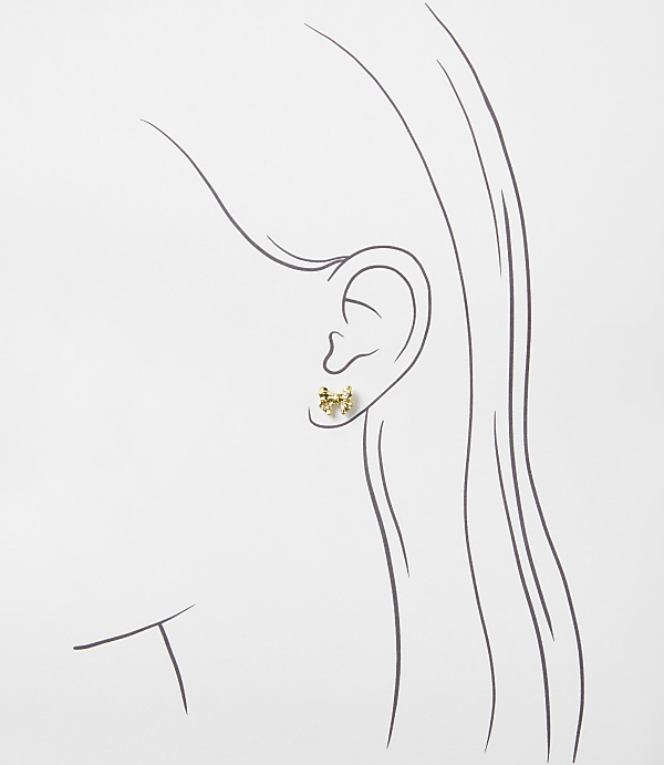 A small gold bow earring is positioned on the ear of a minimalist line drawing of a woman's profile against a plain white background.
