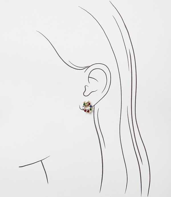 A colorful gemstone earring is placed on a minimalist line drawing of a woman's profile against a plain white background.