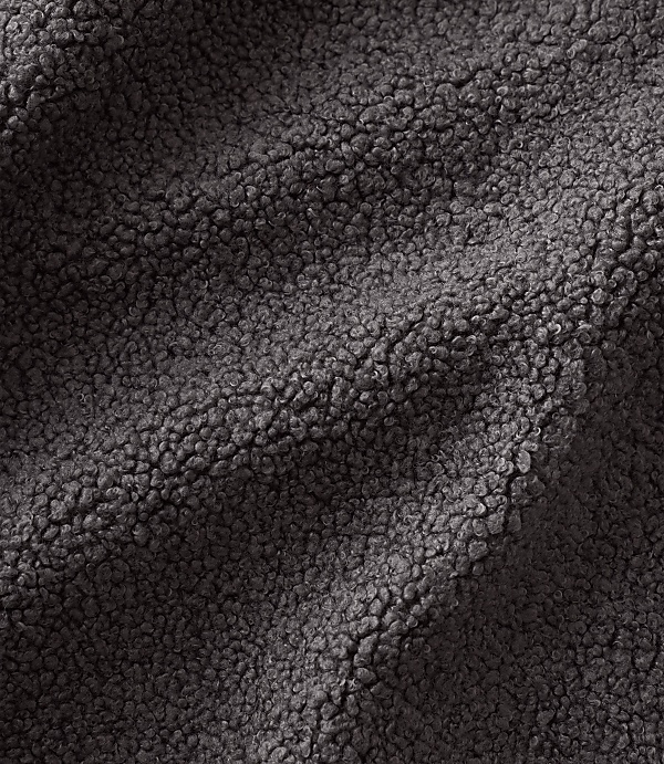 Dark grey, textured sherpa fleece fabric ripples across the foreground and background.