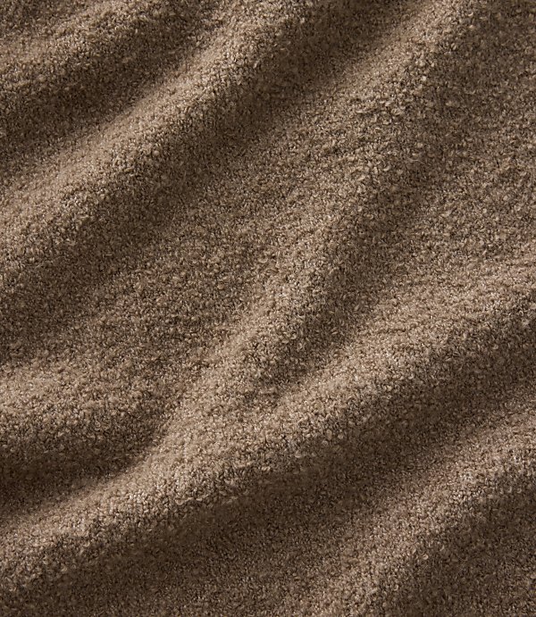 Brown, textured fabric with soft folds in the foreground and a consistent fuzzy pattern throughout the background.