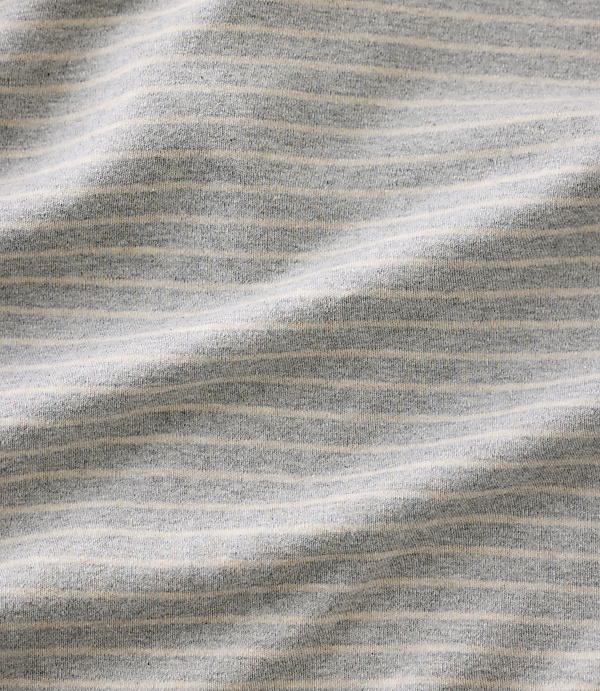 Grey and white striped fabric ripples across the foreground and background.