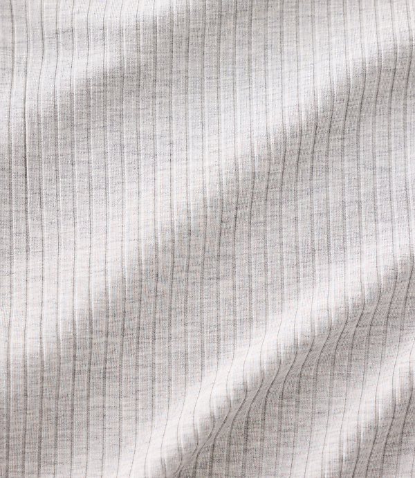 White ribbed fabric with soft folds and shadows fills the entire frame.
