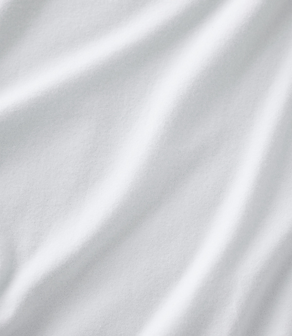 White fabric with soft folds and ripples fills the entire frame from the foreground to the background.