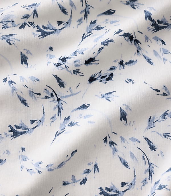 Blue floral patterns are scattered across a white, rippled fabric background.
