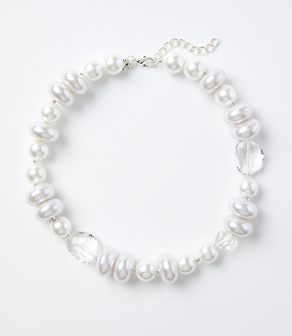 A white pearl and crystal necklace rests on a plain white background.