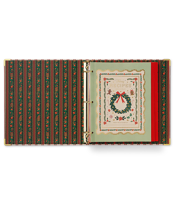 An open, festive green and red patterned binder containing a "Holiday Recipes" page sits against a plain white background.