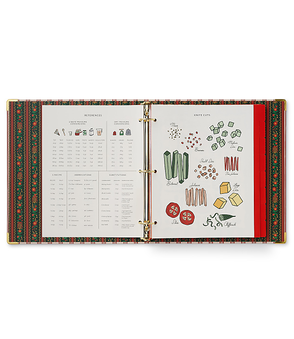 An open recipe binder with measurement references and knife cut guides sits against a plain white background.