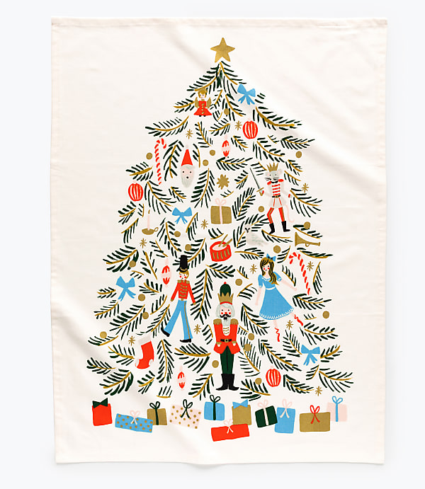 A decorated Christmas tree filled with toys and ornaments stands against a plain white background with wrapped gifts at its base.